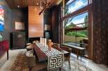 Experience luxurious dining in this elegant space featuring a grand fireplace and a large wooden dining table.