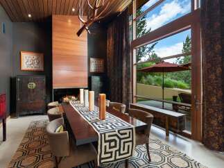 Experience luxurious dining in this elegant space featuring a grand fireplace and a large wooden dining table.