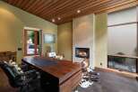 Experience luxury and comfort in this executive office, featuring a stunning wood-paneled ceiling and a modern gas fireplace.