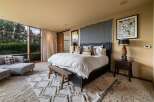 Experience luxurious comfort in this master bedroom, featuring a king-size bed with crisp white linens and plush throw pillows.