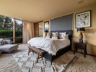 Experience luxurious comfort in this master bedroom, featuring a king-size bed with crisp white linens and plush throw pillows.