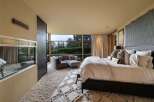 Experience luxury living in this master suite, featuring a plush, oversized rug and a comfortable sectional sofa perfect for relaxation.