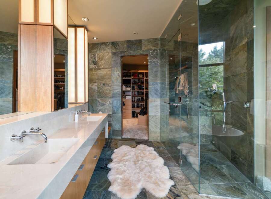 Experience luxury in this master bathroom featuring a spacious walk-in closet and a spa-like glass-enclosed shower.