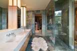 Experience luxury in this master bathroom featuring a spacious walk-in closet and a spa-like glass-enclosed shower.