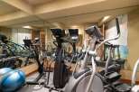 This home gym features a variety of cardio equipment, including ellipticals and stationary bikes, perfect for a full-body workout.