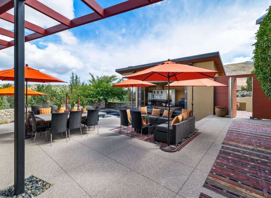 Experience luxurious outdoor living with this stunning patio featuring a dining set and a comfortable lounge area, perfect for entertaining.