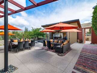 Experience luxurious outdoor living with this stunning patio featuring a dining set and a comfortable lounge area, perfect for entertaining.