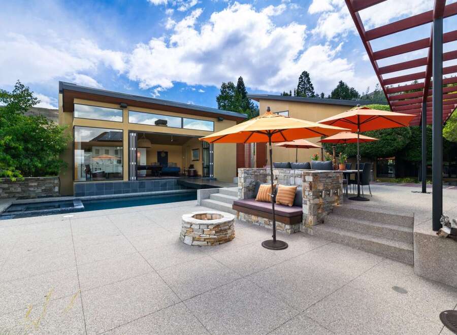 Experience luxurious outdoor living with this stunning patio featuring a sparkling swimming pool and a cozy fire pit.