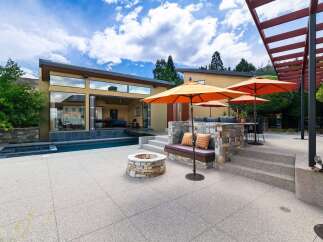 Experience luxurious outdoor living with this stunning patio featuring a sparkling swimming pool and a cozy fire pit.