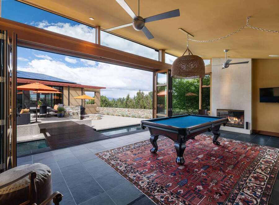 Experience luxury indoor-outdoor living with this stunning home featuring a spacious game room that opens to a beautiful pool and patio area.