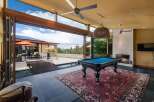 Experience luxury indoor-outdoor living with this stunning home featuring a spacious game room that opens to a beautiful pool and patio area.