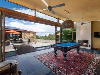 Experience luxury indoor-outdoor living with this stunning home featuring a spacious game room that opens to a beautiful pool and patio area.