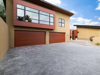 This modern home boasts a striking facade with warm wood accents and expansive windows, offering abundant natural light.