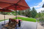 Enjoy outdoor living with this spacious patio featuring comfortable lounge chairs and large umbrellas for shade.
