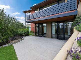 Experience modern living with this stunning home featuring a sleek balcony and expansive glass doors that open to a private patio.
