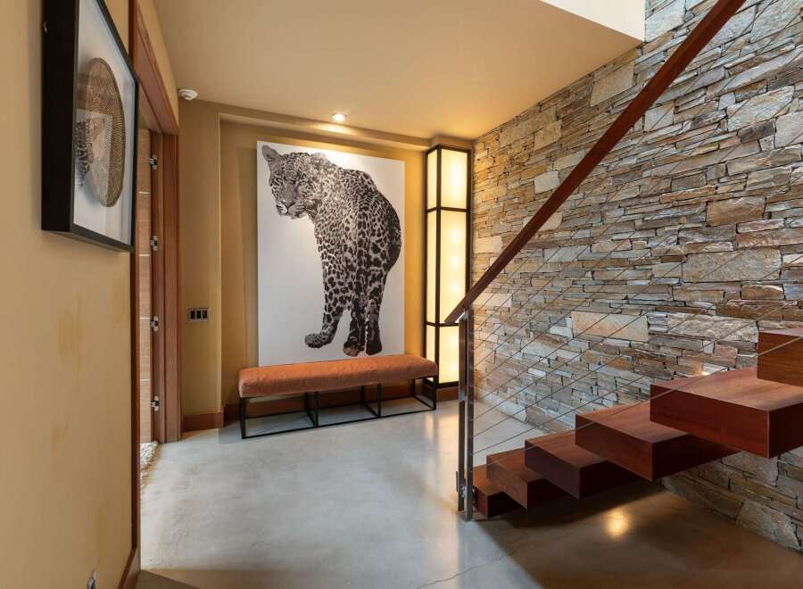 Experience modern luxury in this stunning entryway, featuring a dramatic leopard artwork and a sleek, minimalist bench.
