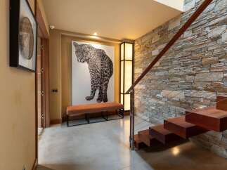 Experience modern luxury in this stunning entryway, featuring a dramatic leopard artwork and a sleek, minimalist bench.