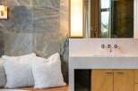 Experience luxury in this modern bathroom featuring a sleek vanity with a stone countertop and warm wood cabinetry.