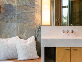Experience luxury in this modern bathroom featuring a sleek vanity with a stone countertop and warm wood cabinetry.