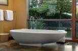 Indulge in ultimate relaxation in this luxurious bathroom, featuring a stunning freestanding bathtub positioned to offer serene garden views.