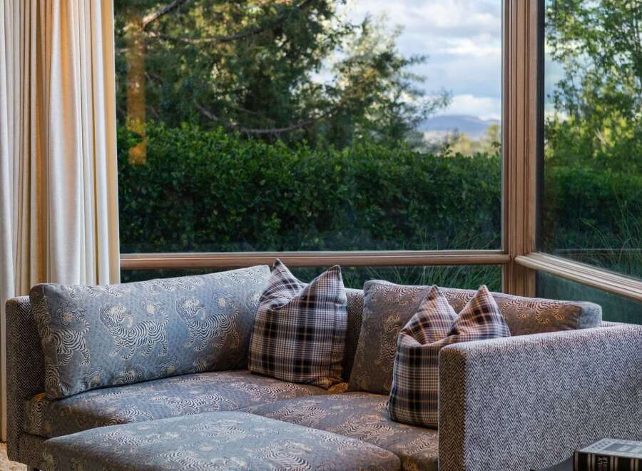 Experience luxurious living with this stunning sectional sofa, featuring a unique blue and white pattern and comfortable plaid accent pillows.