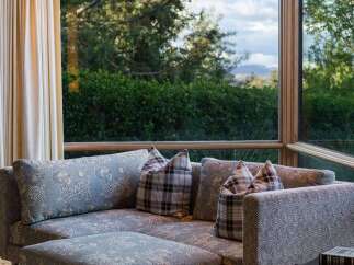 Experience luxurious living with this stunning sectional sofa, featuring a unique blue and white pattern and comfortable plaid accent pillows.