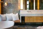Experience luxury in this modern bathroom featuring a freestanding bathtub and a sleek vanity with a stone countertop.