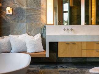 Experience luxury in this modern bathroom featuring a freestanding bathtub and a sleek vanity with a stone countertop.