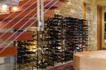 Experience luxury living with this stunning wine cellar, featuring a vast collection of wine bottles neatly organized on sleek metal racks.