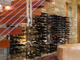 Experience luxury living with this stunning wine cellar, featuring a vast collection of wine bottles neatly organized on sleek metal racks.