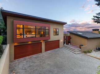 Experience modern luxury in this stunning home featuring a striking cantilevered bedroom with expansive windows offering panoramic views.