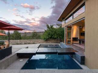 Experience luxury outdoor living with this stunning property featuring a modern infinity pool and expansive patio area, perfect for entertaining.