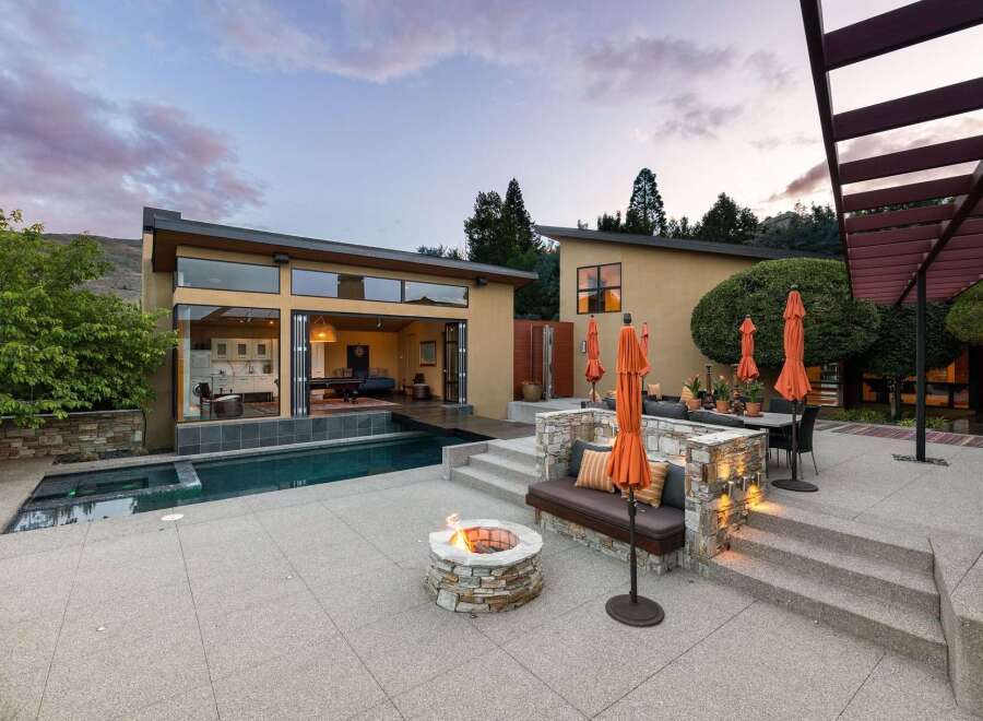 Experience luxury outdoor living with this stunning property featuring a modern home with expansive glass doors opening to a sparkling pool and spa.