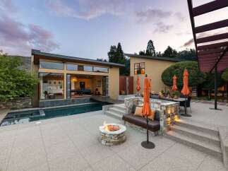 Experience luxury outdoor living with this stunning property featuring a modern home with expansive glass doors opening to a sparkling pool and spa.