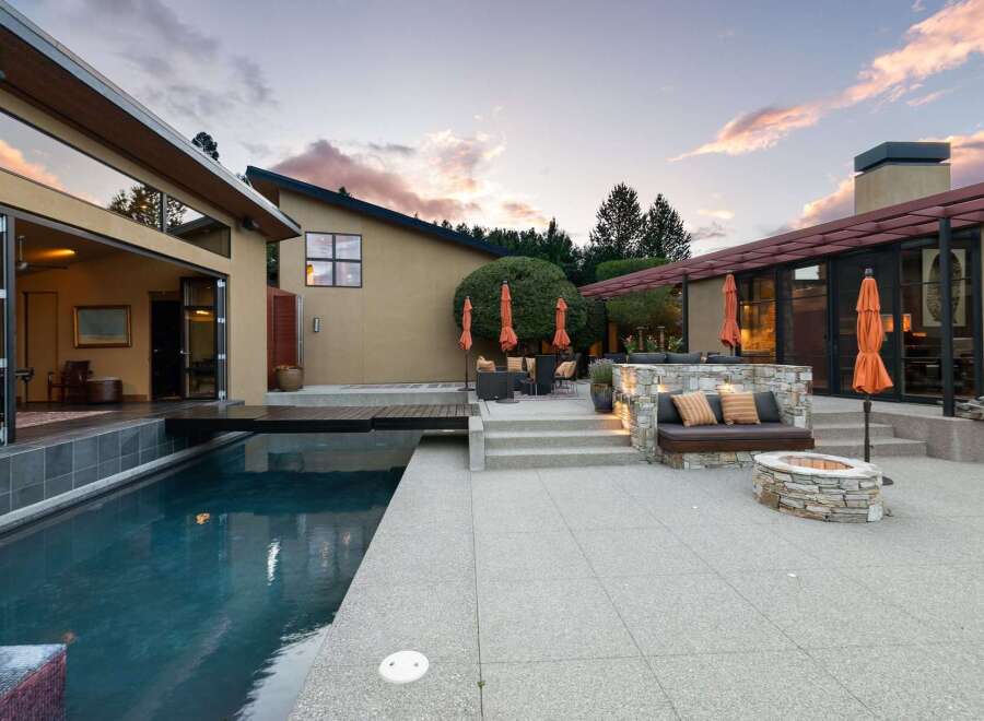 Experience luxurious outdoor living with this stunning property featuring a sleek swimming pool and a modern patio area.