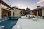 Experience luxurious outdoor living with this stunning property featuring a sleek swimming pool and a modern patio area.