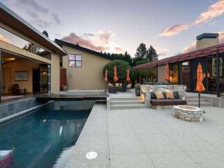 Experience luxurious outdoor living with this stunning property featuring a sleek swimming pool and a modern patio area.