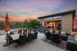 Experience luxurious outdoor living with this stunning patio featuring a dining set, lounge area, and a sparkling pool.