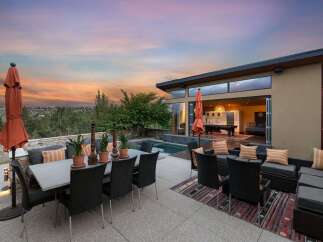 Experience luxurious outdoor living with this stunning patio featuring a dining set, lounge area, and a sparkling pool.