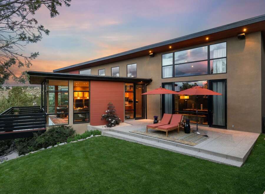 Experience modern luxury in this stunning home featuring expansive windows that capture breathtaking sunset views.