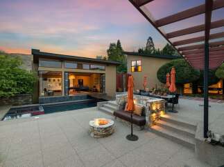Experience luxury outdoor living with this stunning backyard oasis, featuring a modern pool and spa, a cozy fire pit, and a spacious patio perfect for entertaining.