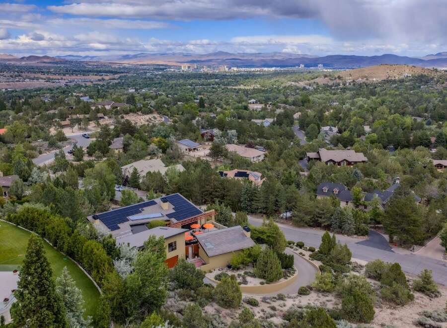 Experience luxury living in this stunning home, nestled amidst lush greenery and offering panoramic views of the distant city and mountains.