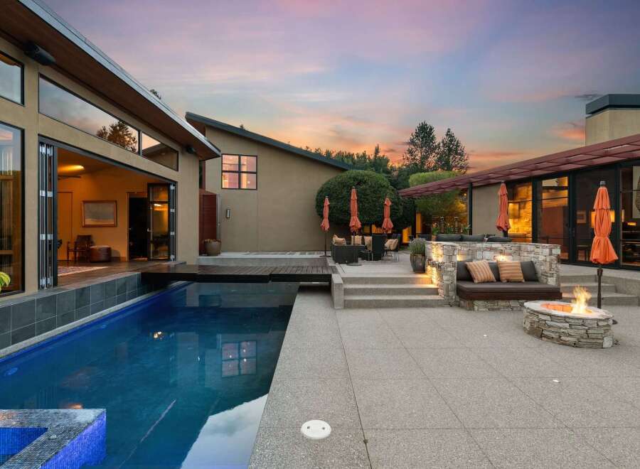 Experience luxurious outdoor living with this stunning property featuring a sparkling swimming pool and a cozy fire pit area perfect for evening gatherings.