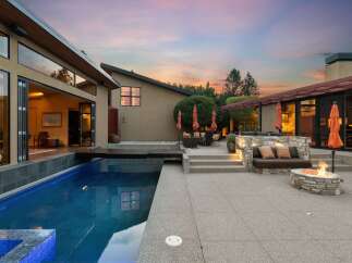 Experience luxurious outdoor living with this stunning property featuring a sparkling swimming pool and a cozy fire pit area perfect for evening gatherings.