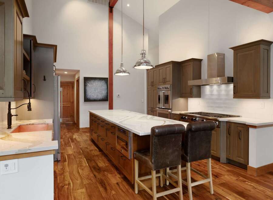 Experience luxury in this stunning gourmet kitchen, featuring a spacious island with a waterfall countertop and ample storage.