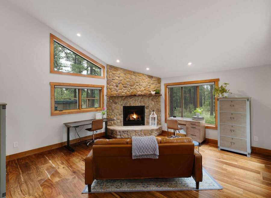 Experience rustic charm in this inviting living room, featuring a stunning floor-to-ceiling stone fireplace as the centerpiece.