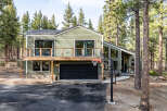 Experience modern mountain living in this stunning green home nestled among tall pine trees.