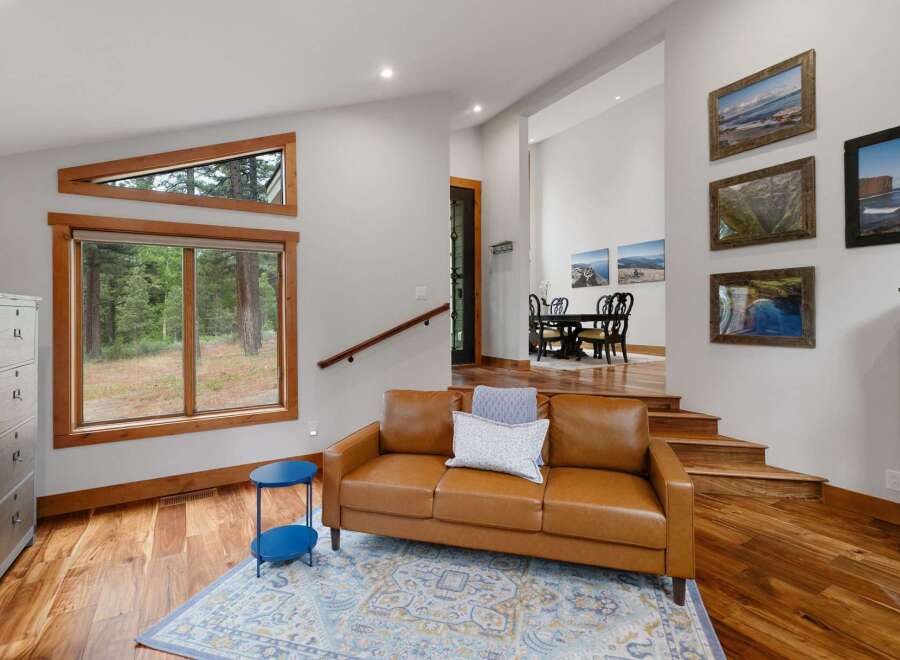 Experience modern living with stunning natural light pouring through unique triangular and large windows, offering picturesque forest views.