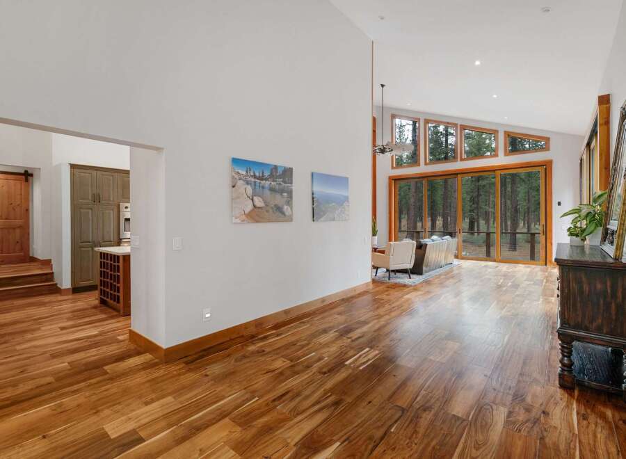 Experience breathtaking natural beauty from this stunning home, featuring expansive windows that frame a serene forest view.