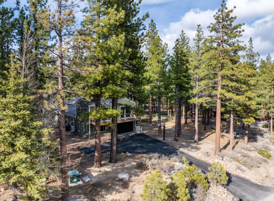 Nestled amidst towering pine trees, this stunning property offers a serene mountain retreat.